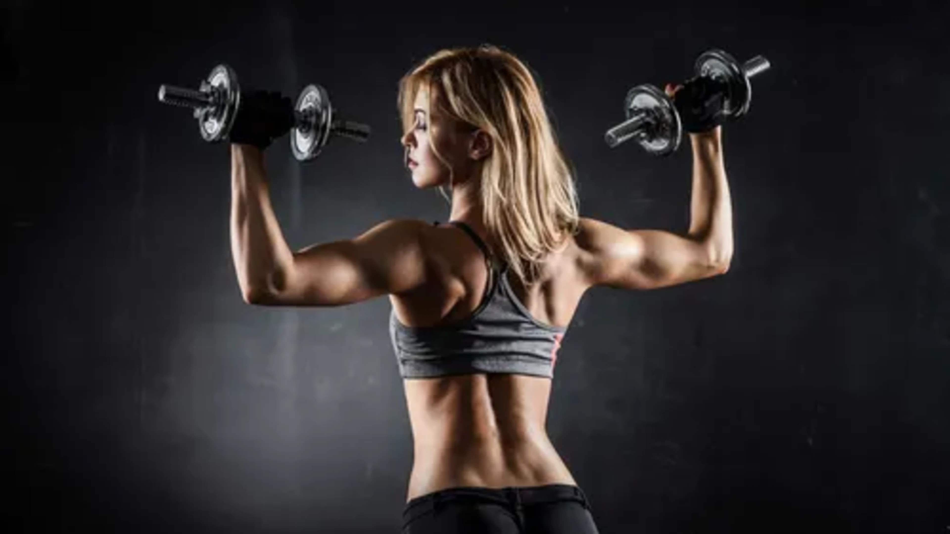 Athlete training shoulders with dumbbells